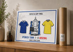 Poster of 1978 FA Cup Final between Ipswich Town and Arsenal on a wooden surface with a plant and book.