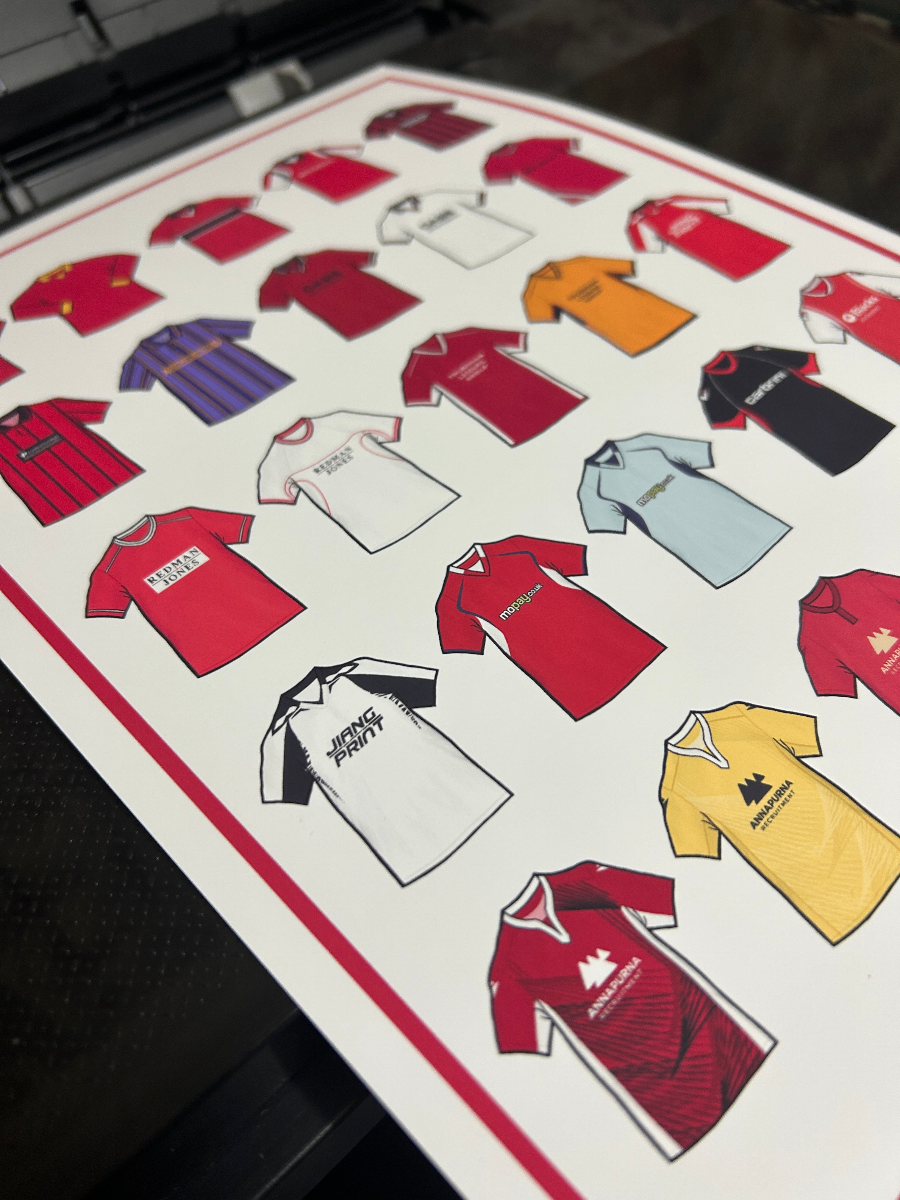 Poster artwork inspired by Morecambe FC shirts, featuring a stylized design with bold red and white color elements. The piece incorporates vintage jersey patterns and textures, capturing the proud tradition and rich heritage of Morecambe Football Club. It blends classic elements with a sharp, contemporary aesthetic that celebrates the enduring spirit of the Shrimps and the club’s historic legacy at the Mazuma Stadium