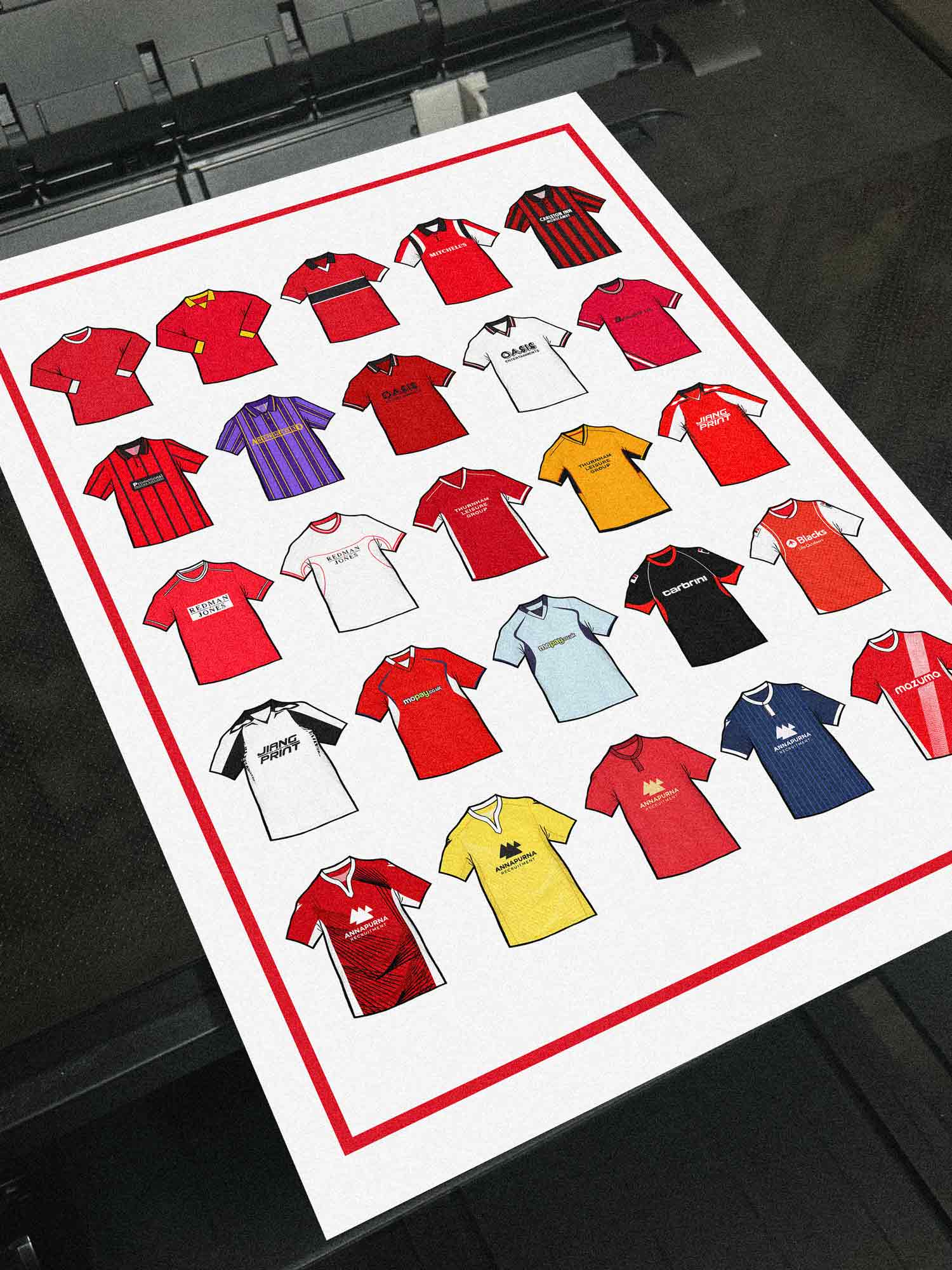 Poster artwork inspired by Morecambe FC shirts, featuring a stylized design with bold red and white color elements. The piece incorporates vintage jersey patterns and textures, capturing the proud tradition and rich heritage of Morecambe Football Club. It blends classic elements with a sharp, contemporary aesthetic that celebrates the enduring spirit of the Shrimps and the club’s historic legacy at the Mazuma Stadium